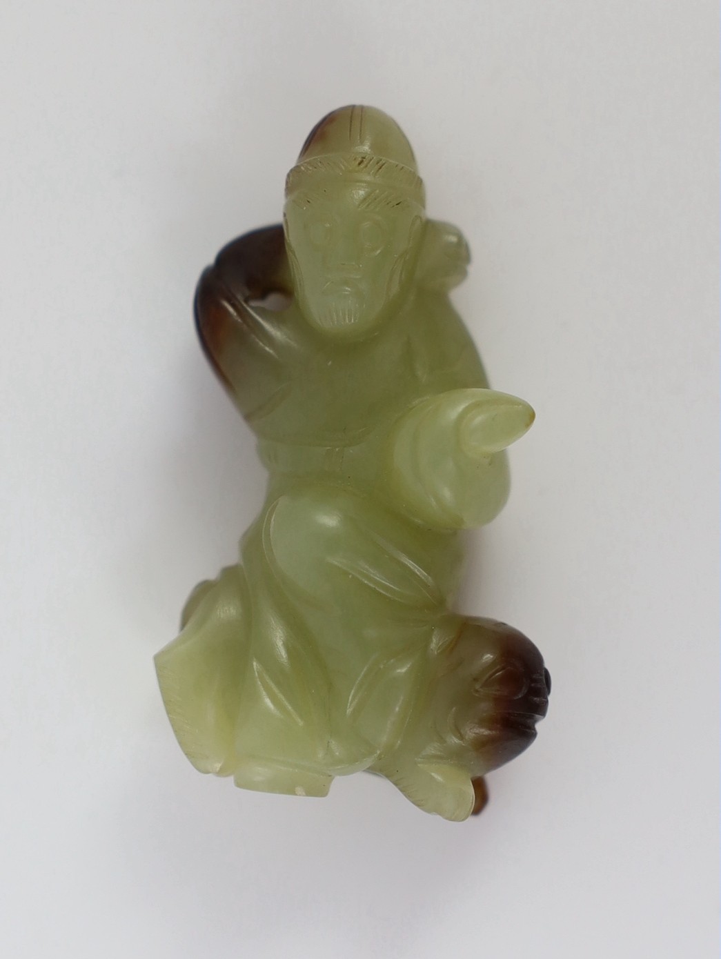 A Chinese yellow and brown jade figure of a man seated on a creature, 19th century, 4.3cm high